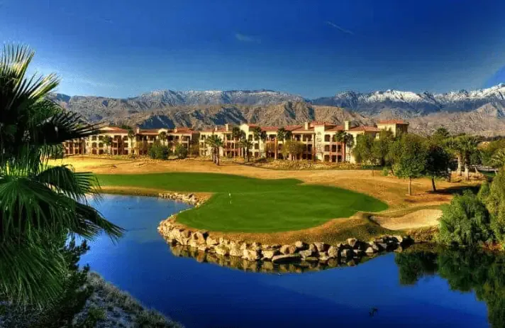 A golf course with mountains in the background providing golf course management services.