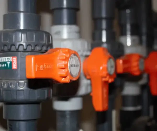 A row of Aquatic valves with orange handles.