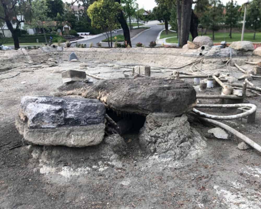 A construction site with a large rock in the middle of it.