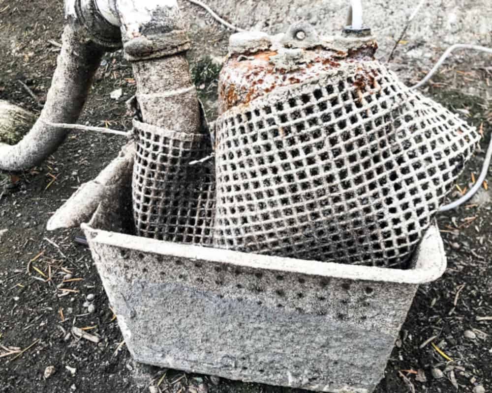 A metal basket with a pipe in it.