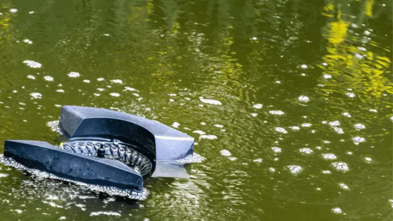 A broken piece of machinery is partially submerged in a murky, foamy body of water, surrounded by floating skimmers attempting to clear the debris.