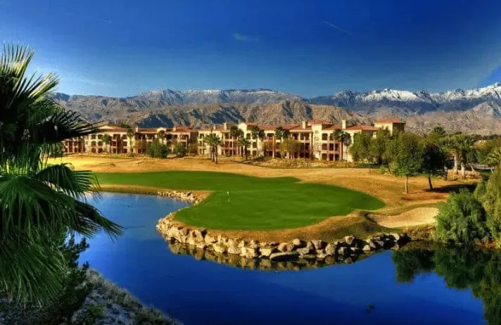 A golf course with mountains in the background providing golf course management services.