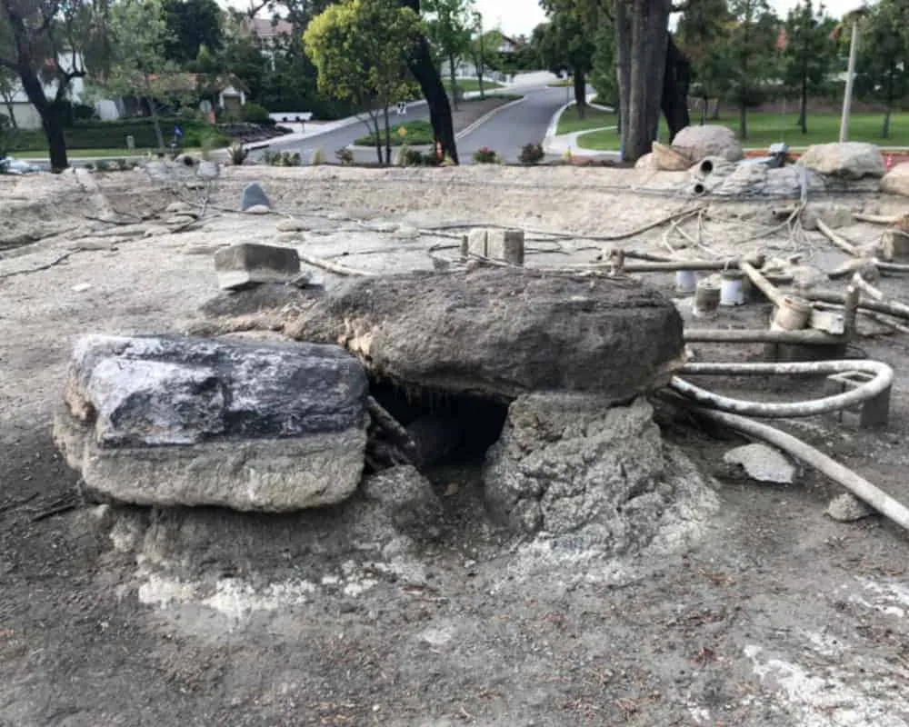 A construction site with a large rock in the middle of it.