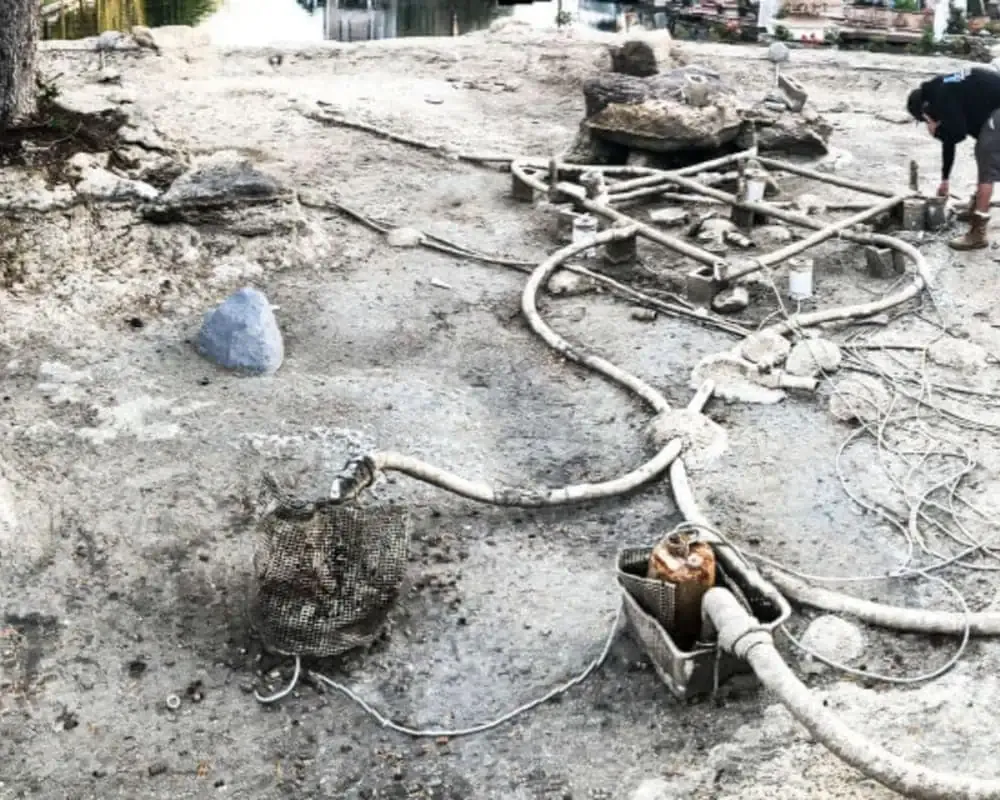 A man is working on a construction site near a lake.